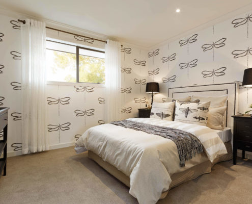 Modern, luxury bedroom with patterned wall paper.