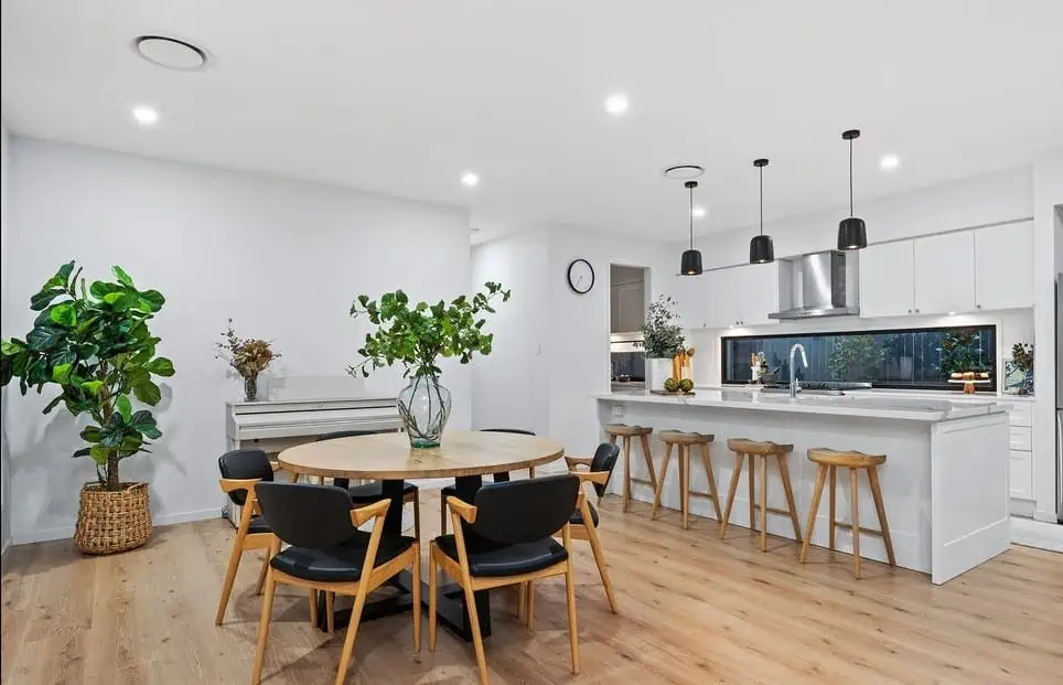 Modern white kitchen dining area with island and plants