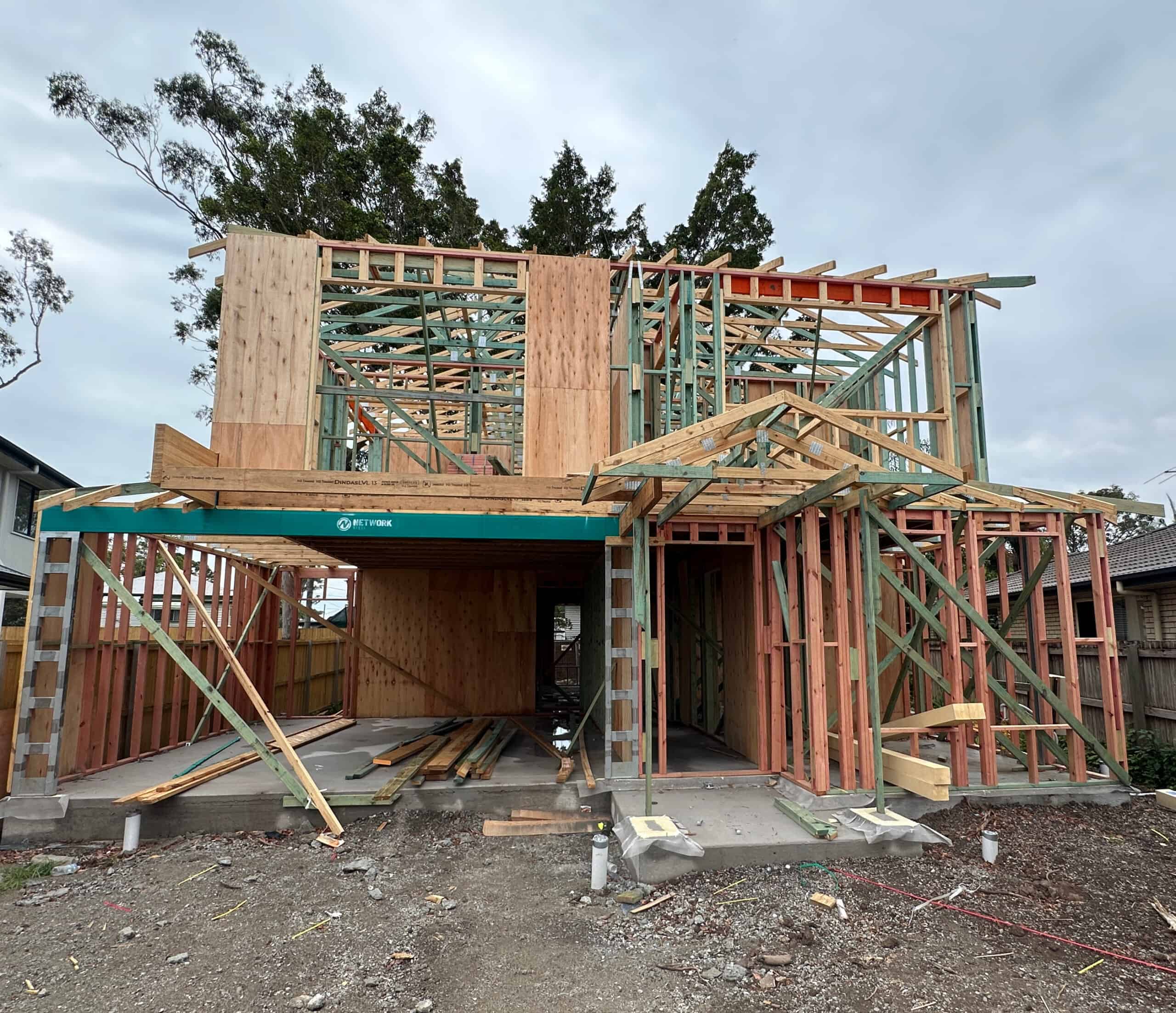 An image of a house in the construction phase, highlighting its steel framework and construction materials.