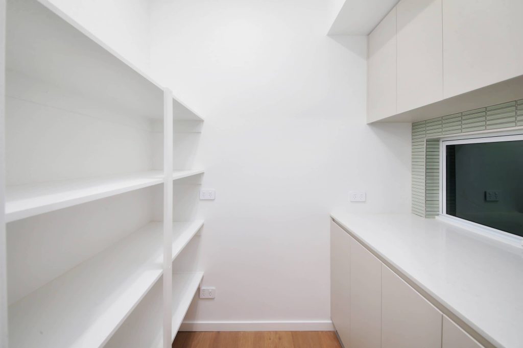 Walk-in pantry with open shelving and benchtop storage in an Alderley custom home