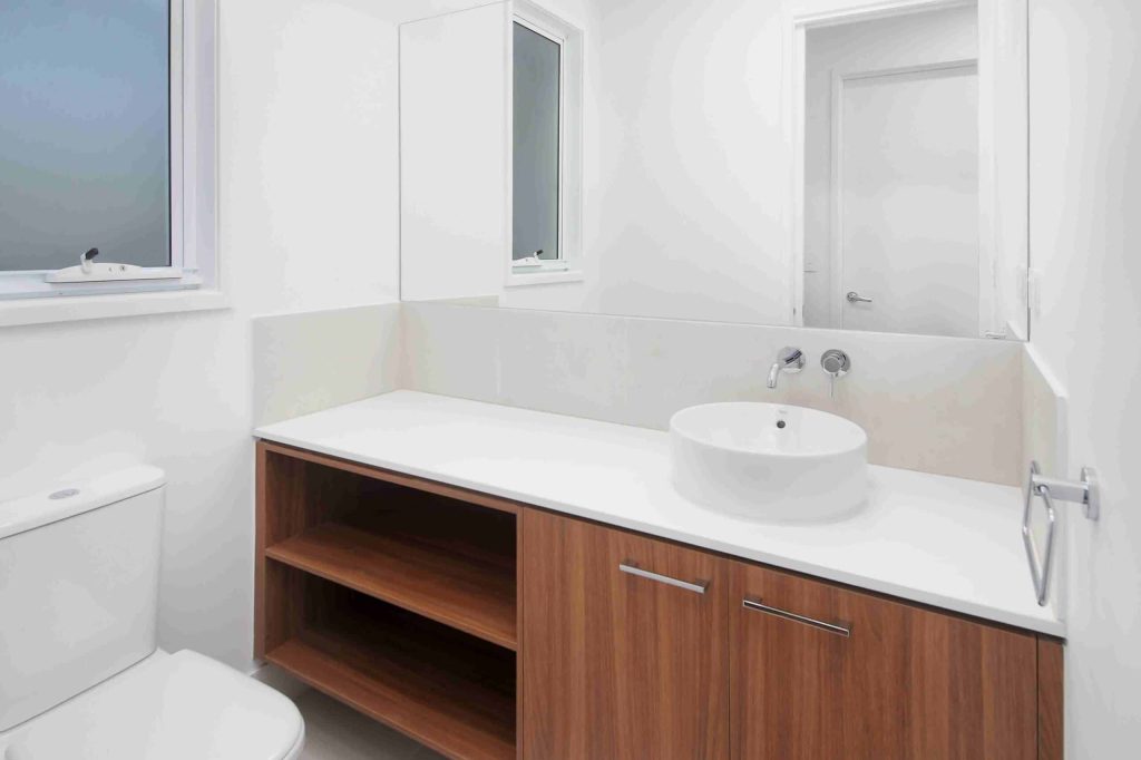 Powder room with timber vanity, round basin and wall mounted tapware in a Sunnybank custom home