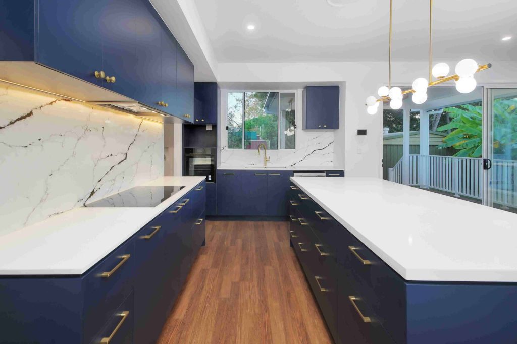 Kitchen with navy cabinetry, marble splashback and brass hardware in a Sunnybank custom home