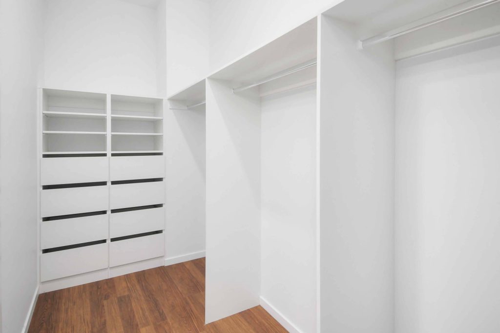 Walk-in wardrobe with built-in shelving and drawers in a Sunnybank custom home