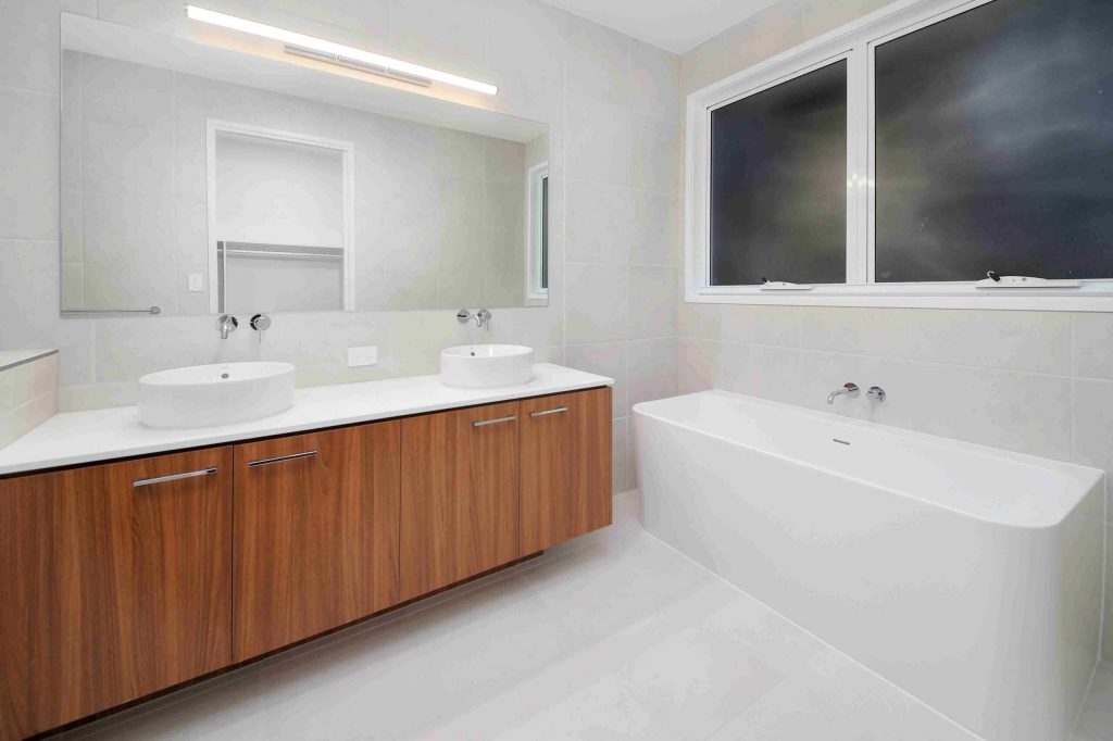 Ensuite with double vanity, timber cabinetry and freestanding bath in a Sunnybank custom home