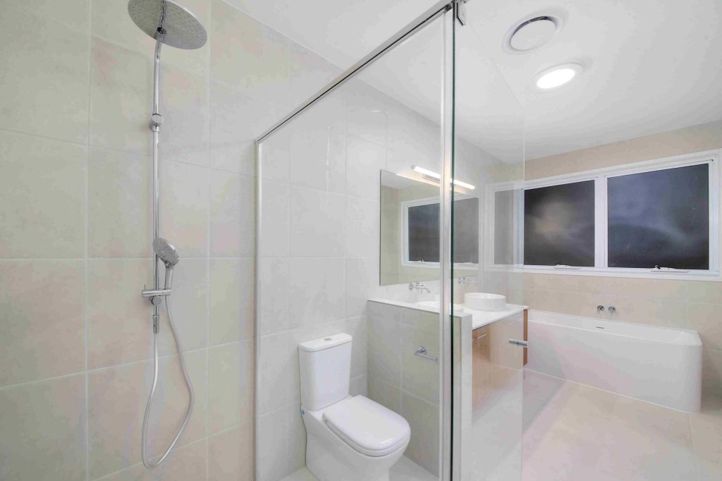 Modern bathroom with glass walk-in shower, freestanding bath and vanity in a Sunnybank custom home