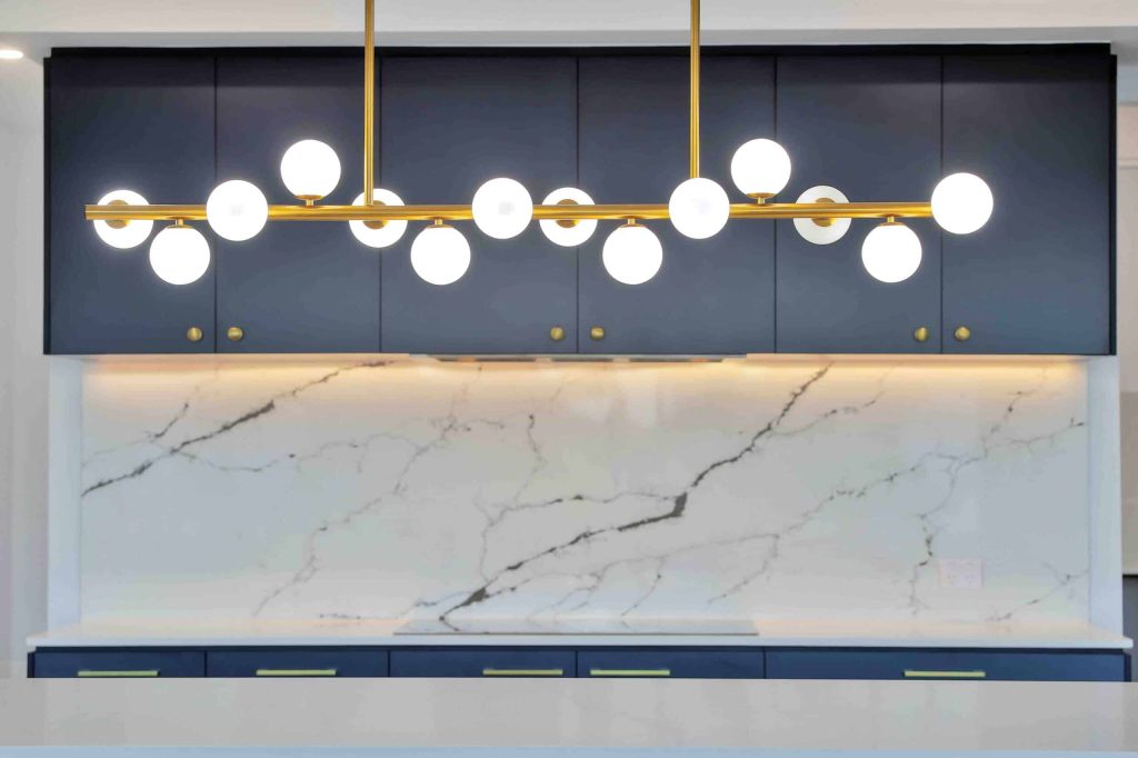Brass pendant light over marble splashback and navy cabinetry in a Sunnybank custom home
