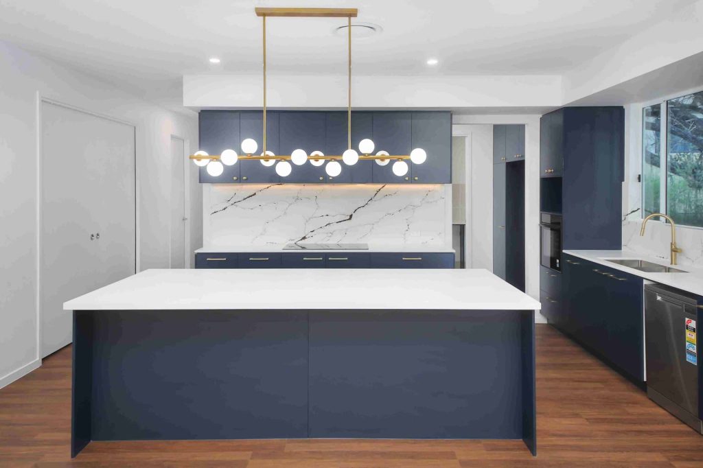Modern kitchen with navy cabinetry, stone benchtops and gold tapware in a Sunnybank custom home