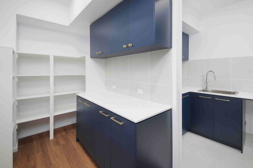 Butlers pantry with navy cabinetry, open shelving and sink in a Sunnybank custom home